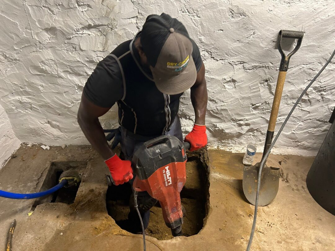 Drycrete crew digging into a basement slab
